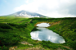 姿見散策コースにある「すり鉢池」。遠方に見えるのが旭岳