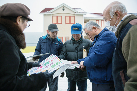 地図で訪問先を確認。右から丸山さん、飯田さん、工藤勝男さん