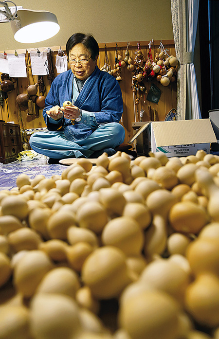 ひょうたんに丁寧に紐飾りをつける安田さん