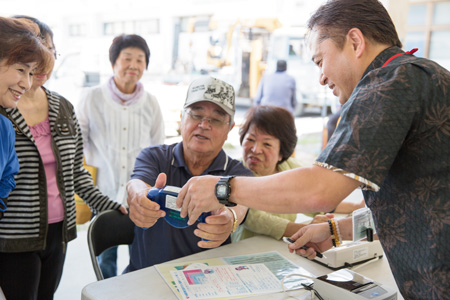 大勢の島民が参加した健康チェック。右端は知念毅さん