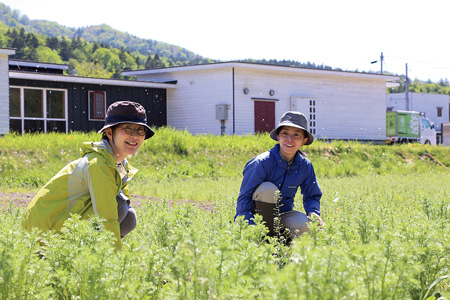 バイオビレッジ裏に広がるハーブ園で作業する山田さん（左）と小松さん