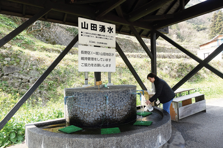 鹿鳴越連山から湧き出る清水を汲むことができる山田湧水