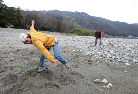 全身を使って石を投げる水切り名人の岡林さん（左）と生野さん