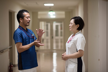 眞柄さんと病院の廊下で話す武田さん（左）