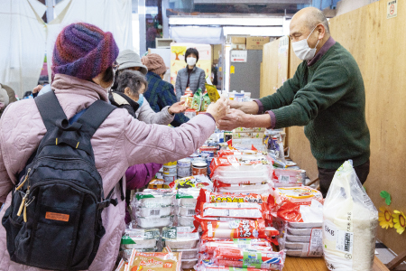 食材を手渡す友の会の南雲副会長（右）