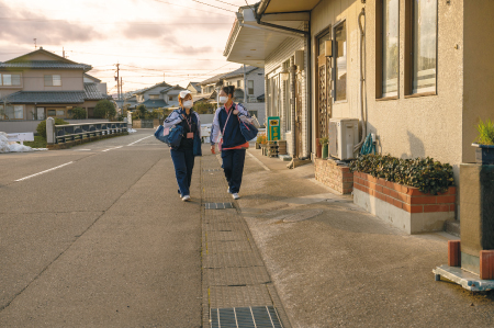 夕刻の福井市街、ケアを終え利用者宅からの帰り道。光陽訪問看護ステーション所長の寺本さん（左）と瀬戸川さん