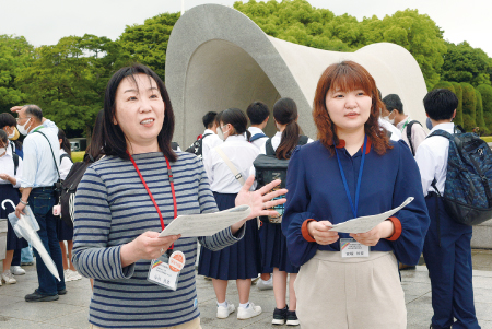 原爆死没者慰霊碑の前で話す中村さん（左）と宮塚さん