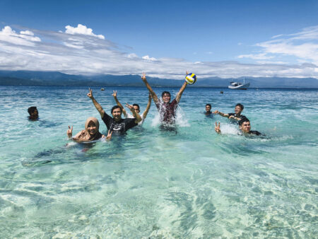 スラウェシ島の透明度の高い海で、インドネシアの若者の笑顔が弾ける